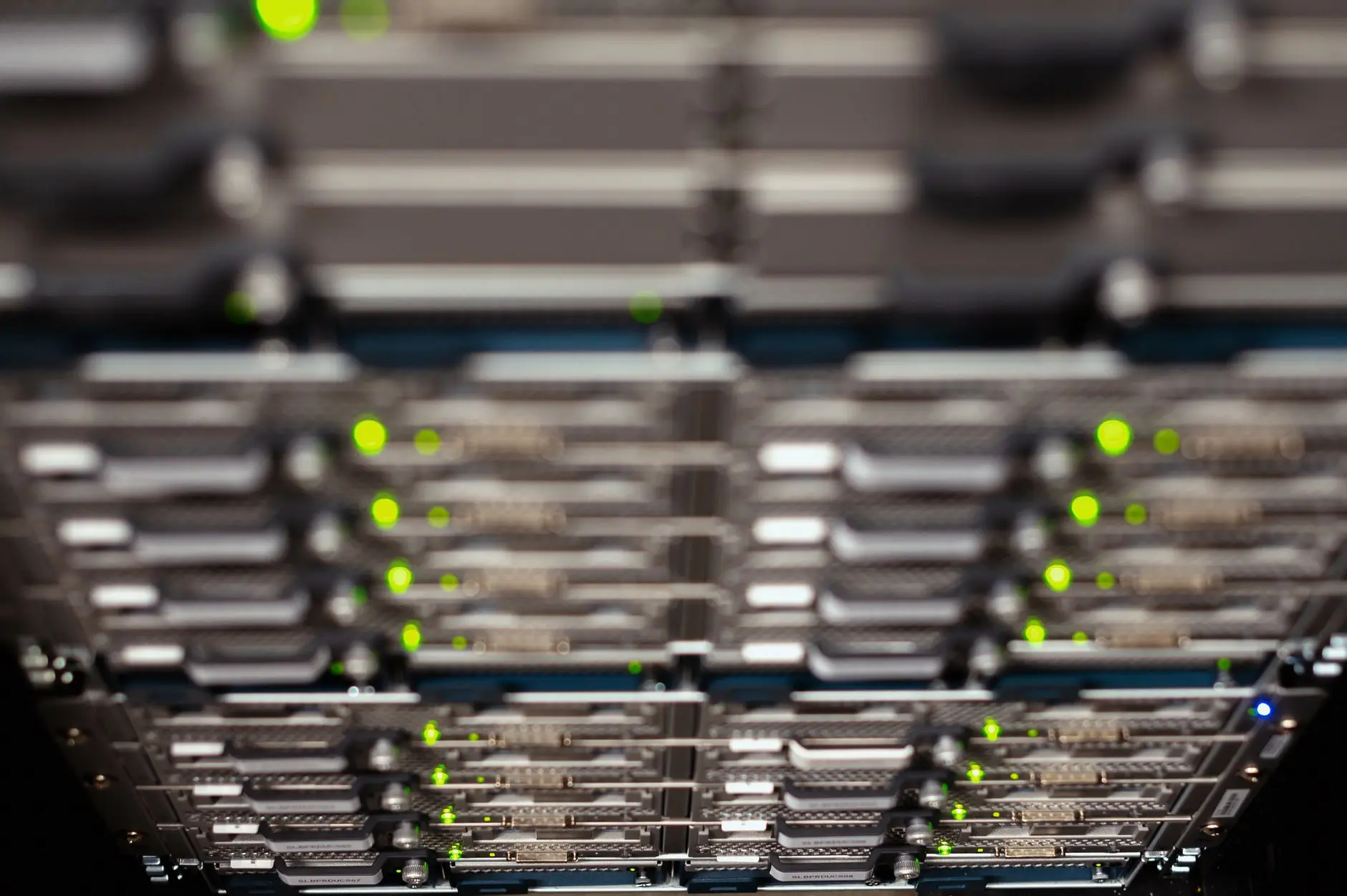 Close-up of server racks with blinking green indicator lights in a data center.