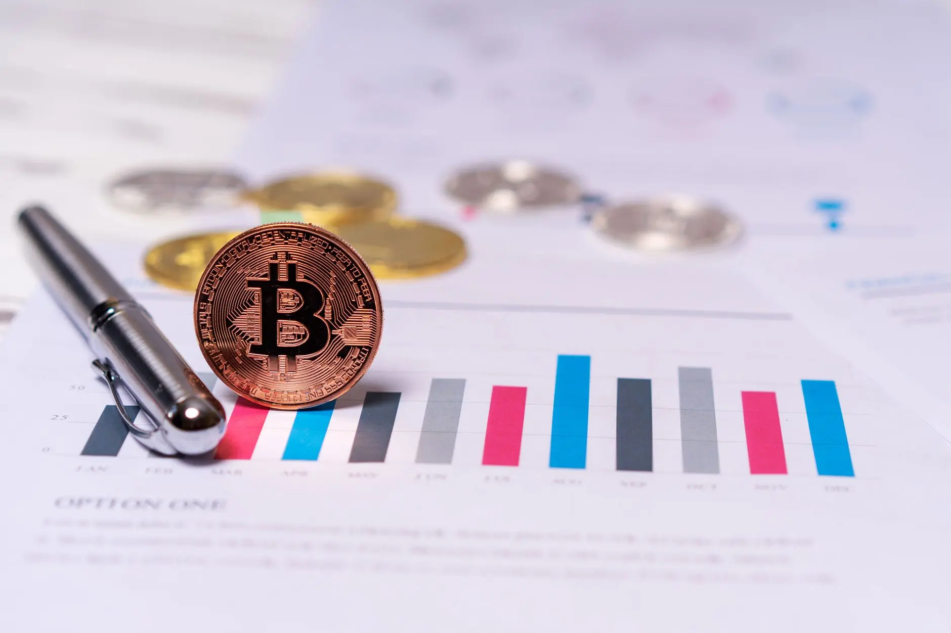 A Bitcoin coin on a financial chart with bars in different colors.