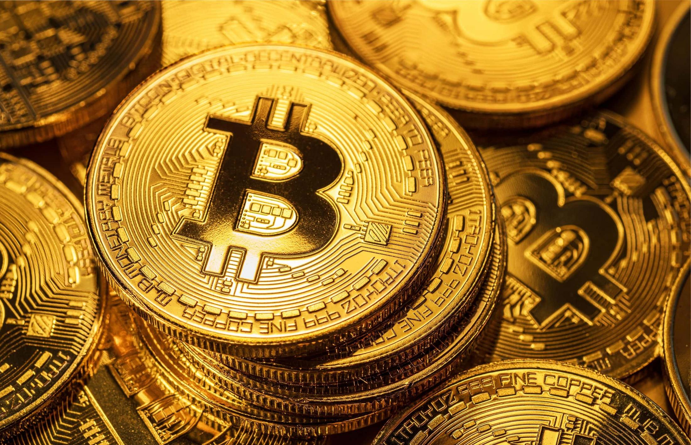 A close-up of golden Bitcoin coins stacked together.
