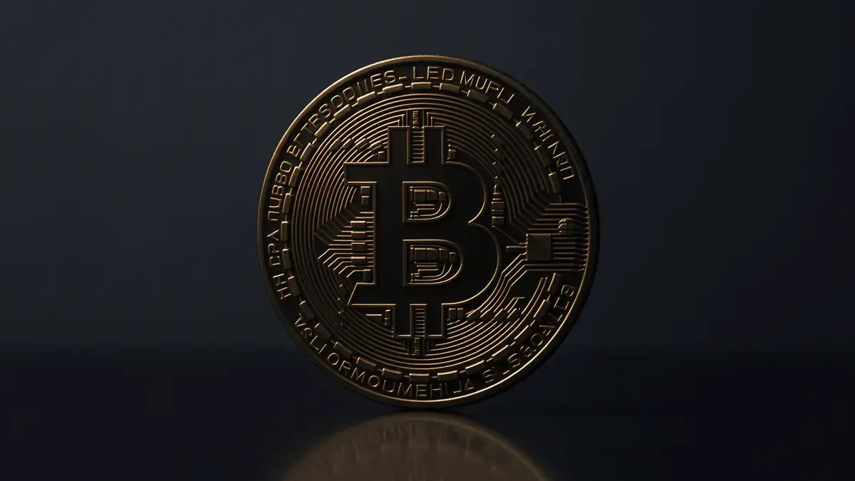 A close-up view of a Bitcoin coin with a dark background.
