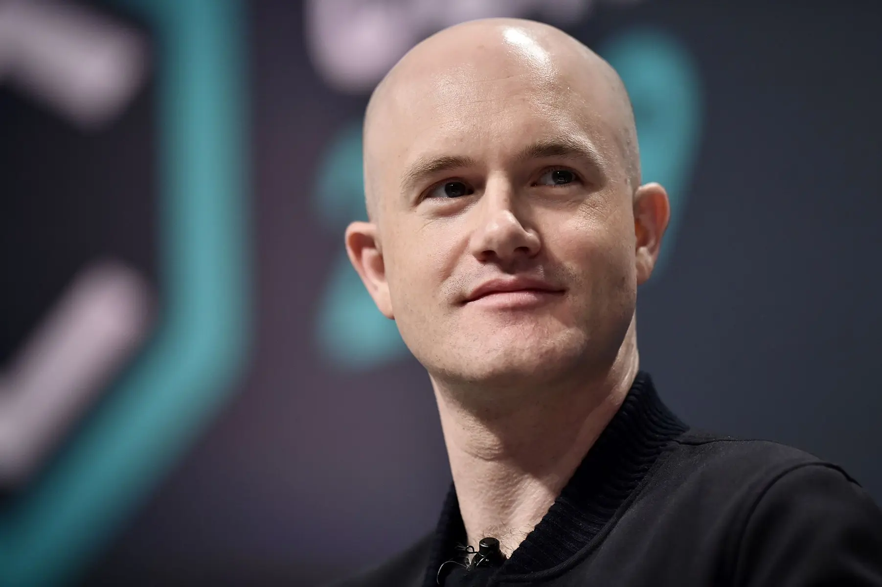 Portrait of Brian Armstrong, CEO of Coinbase, smiling at an event