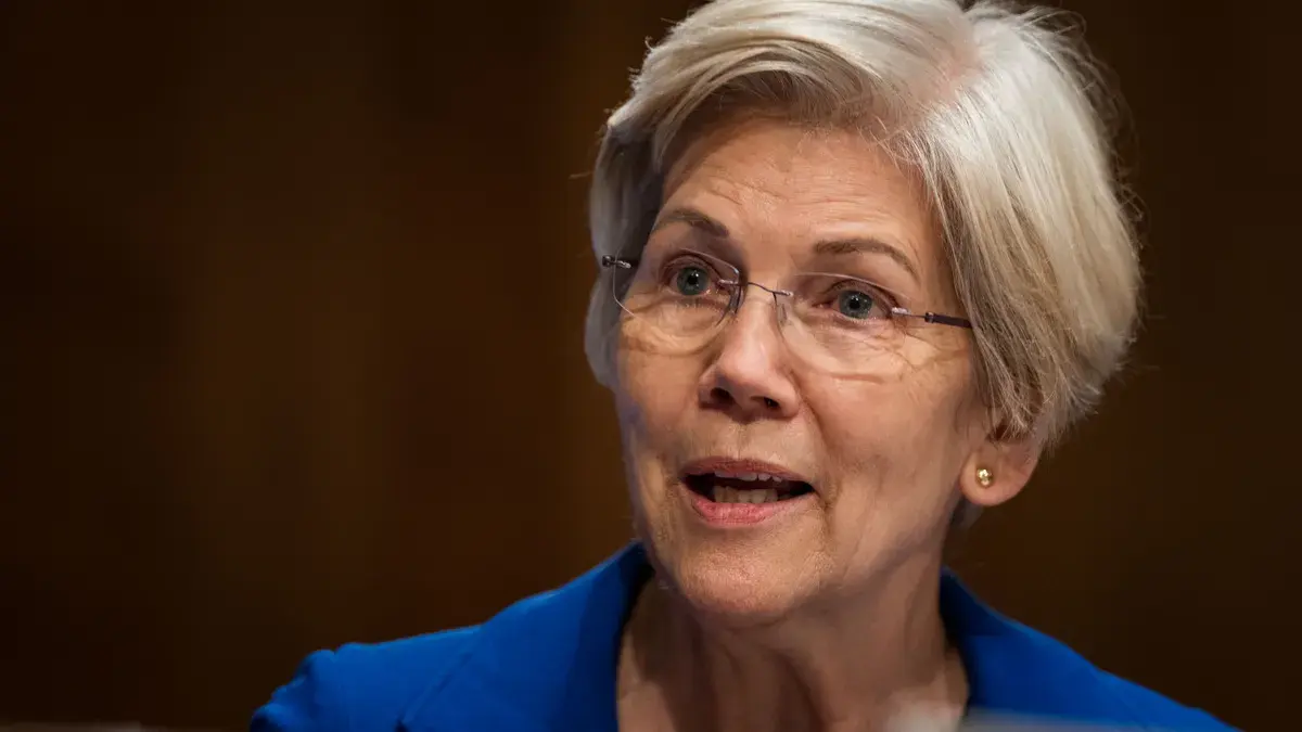 Close-up of a woman speaking at a Senate hearing with light wooden background.