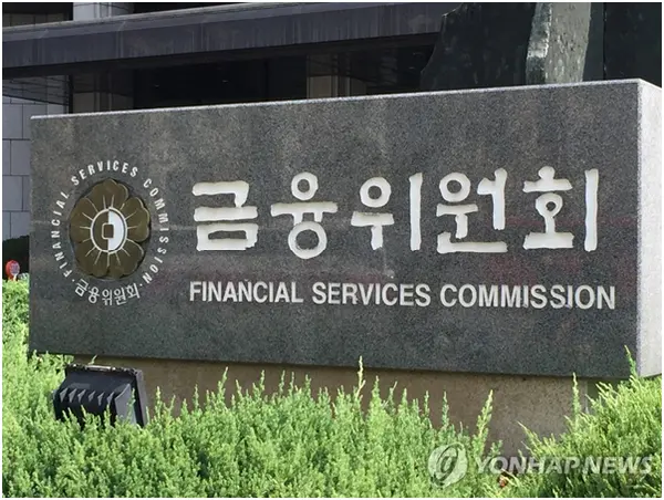 Sign of the Financial Services Commission in South Korea with greenery in front.