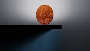 Bitcoin coin on edge of structural precipice representing $52K price floor and market decline
