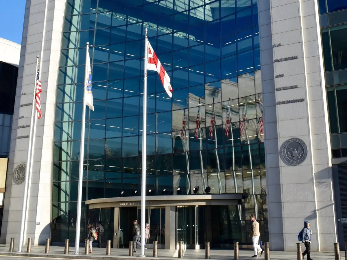SEC headquarters building in Washington, D.C. with flags and glass facade.