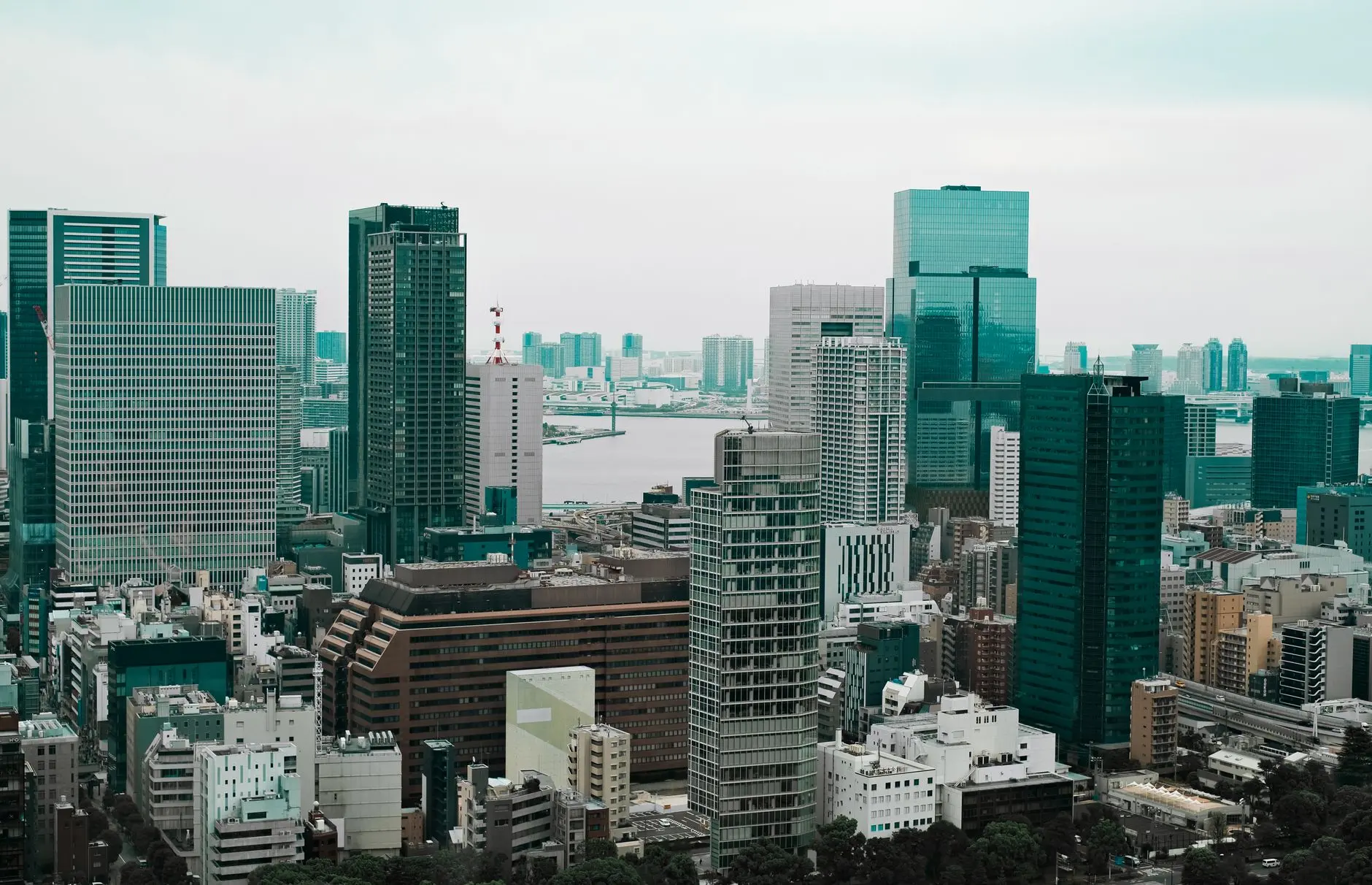 Tokyo financial district skyline featuring modern skyscrapers and a waterway.