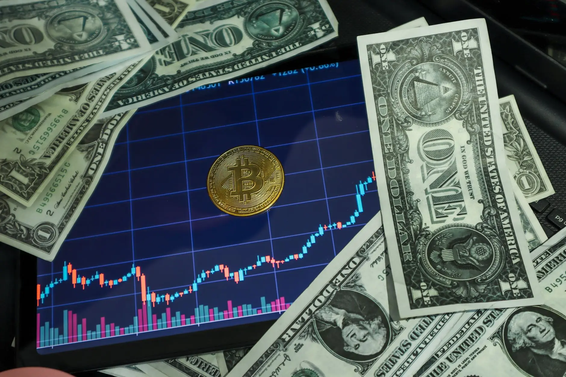 Bitcoin on a chart surrounded by US dollar bills.