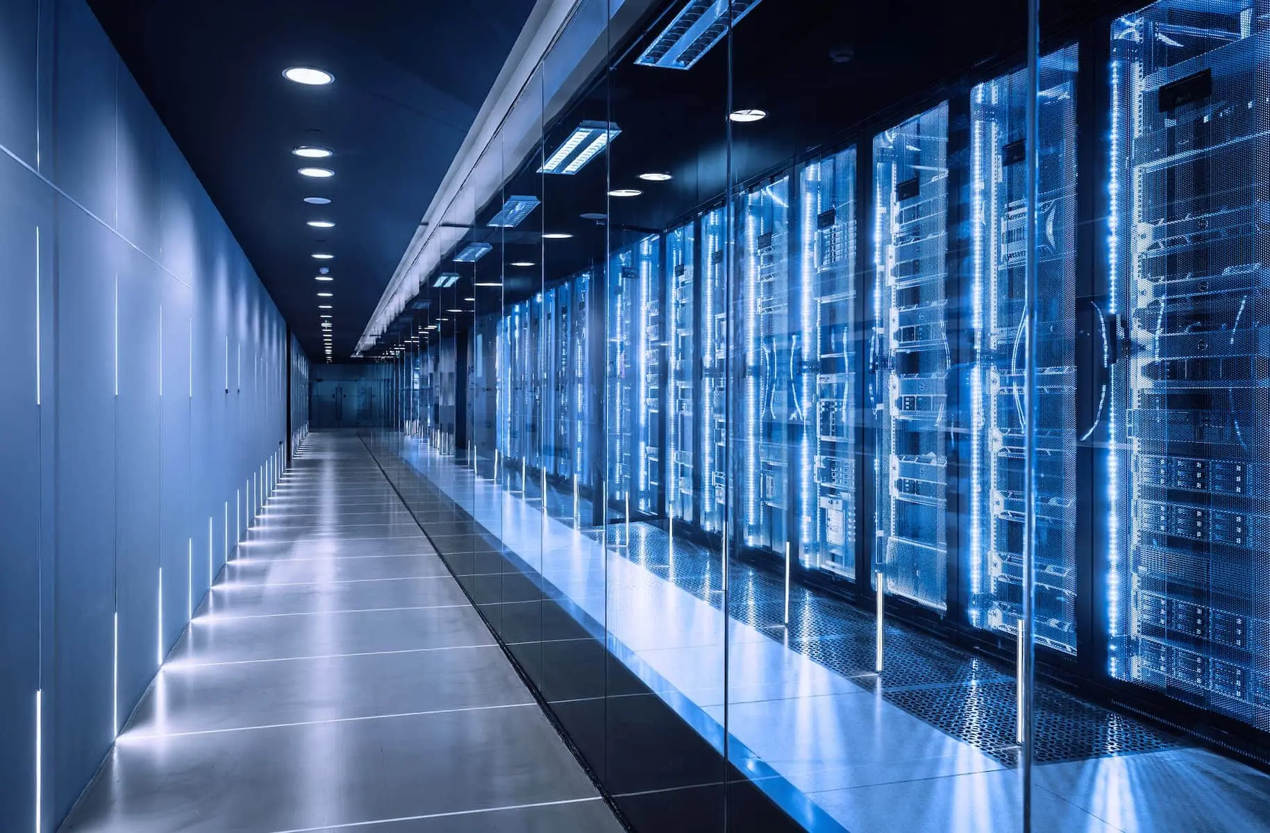 A long row of glowing blue server racks in a modern, high-tech data center hallway