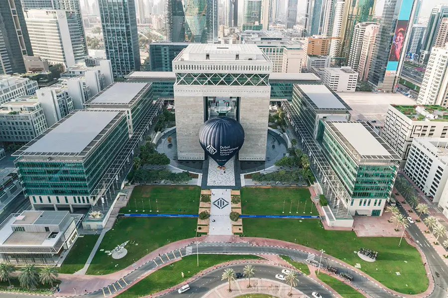 Aerial view of the Dubai International Financial Centre (DIFC) with a large blue hot air balloon in the courtyard.