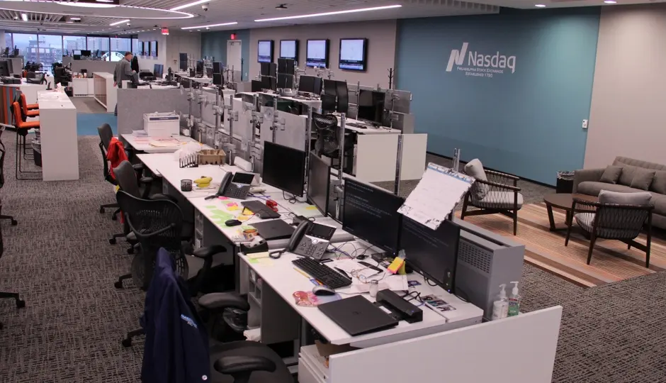 Interior view of the Nasdaq Philadelphia Stock Exchange floor featuring trading desks and a Nasdaq wall logo