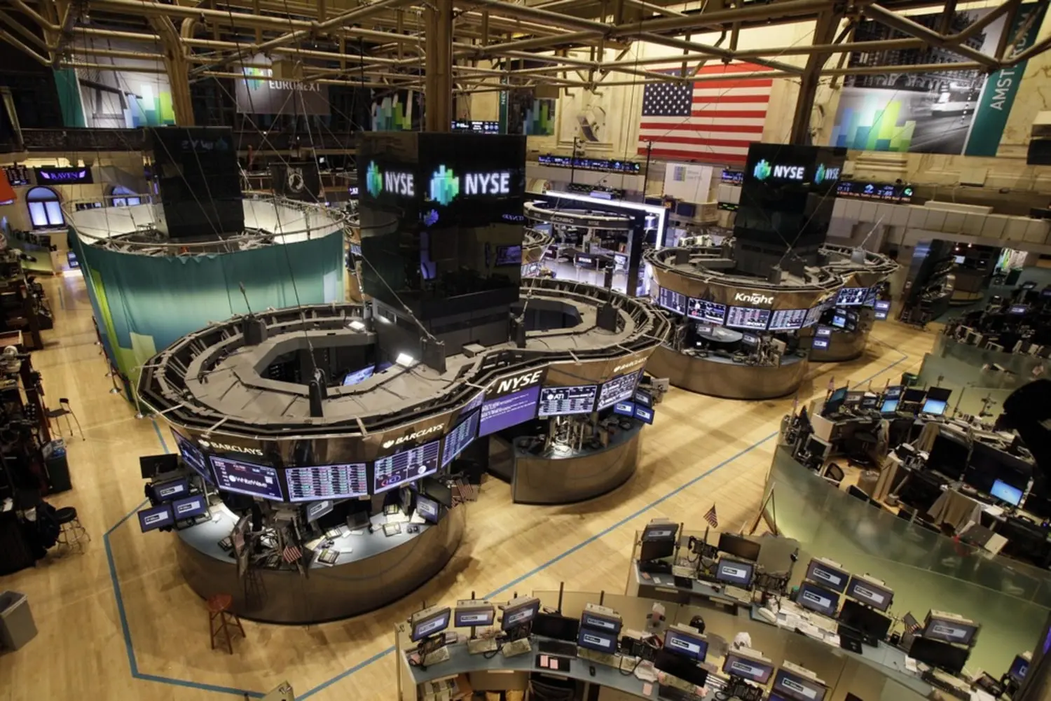 High-angle view of the New York Stock Exchange trading floor with circular trading pods and electronic displays