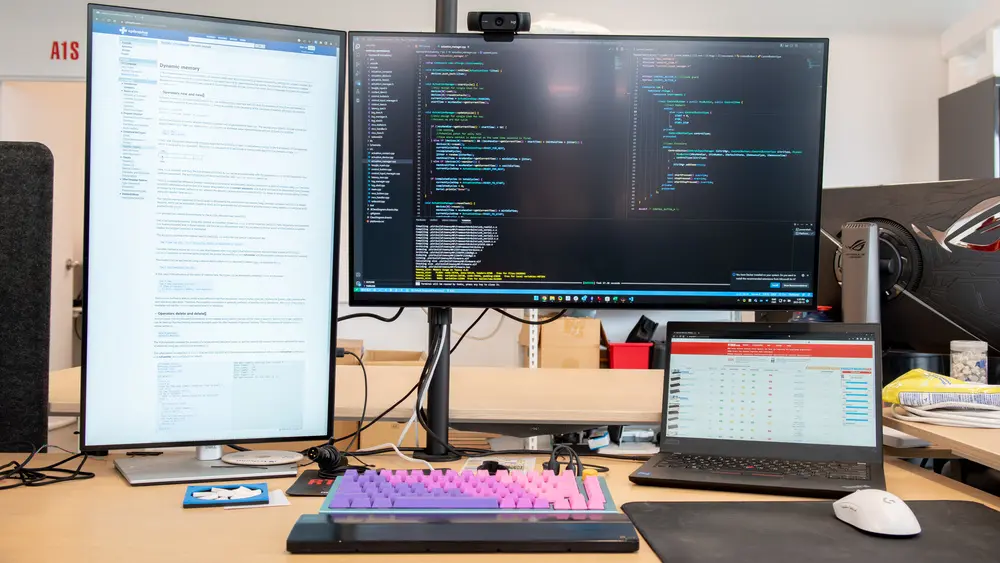 Developer workstation with a dual monitor setup displaying code and technical documentation