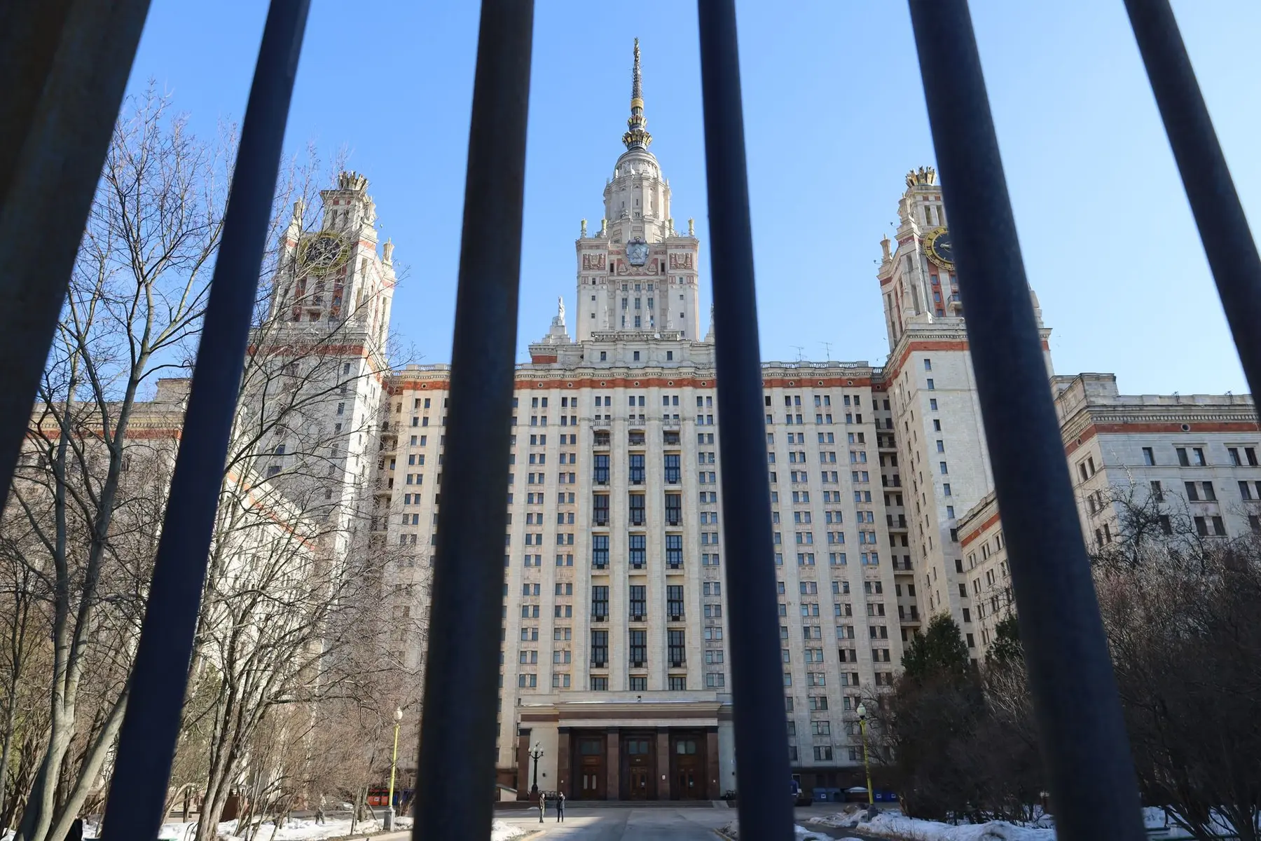 Exterior view of the State Duma building in Moscow seen through a dark metal fence