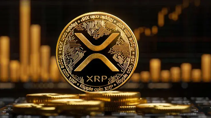 A gold XRP cryptocurrency coin standing on a stack of coins with a blurred financial chart in the background