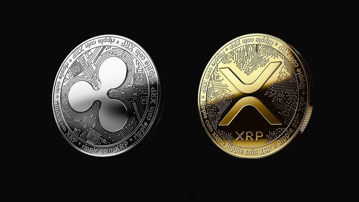 A silver and a gold physical XRP Ripple cryptocurrency token side by side on a black background