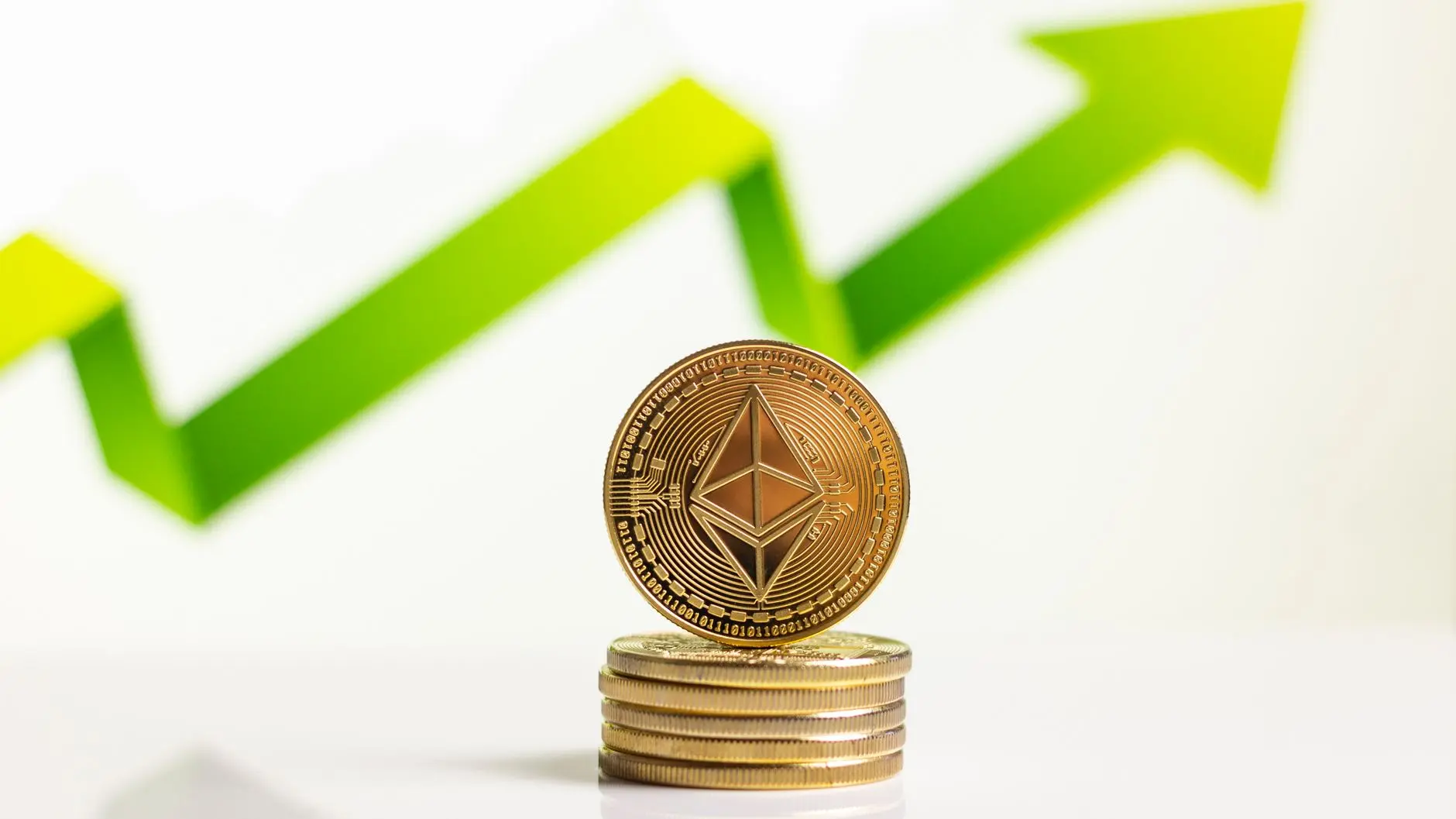 A stack of gold Ethereum ETH coins with a blurred green growth arrow in the background