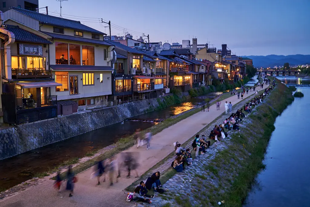 Traditional buildings and a river walk in Kyoto, Japan during twilight.