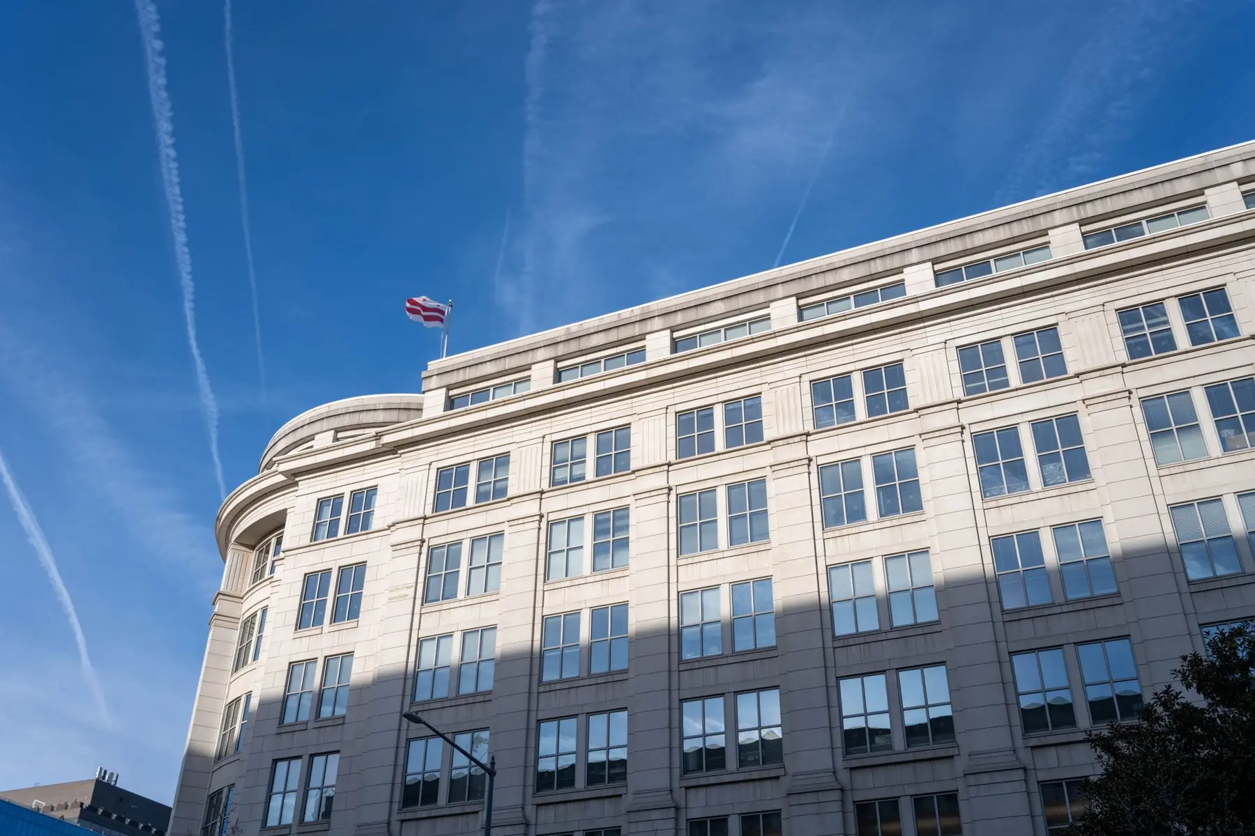 Exterior view of the Securities and Exchange Commission headquarters building under a blue sky with contrails
