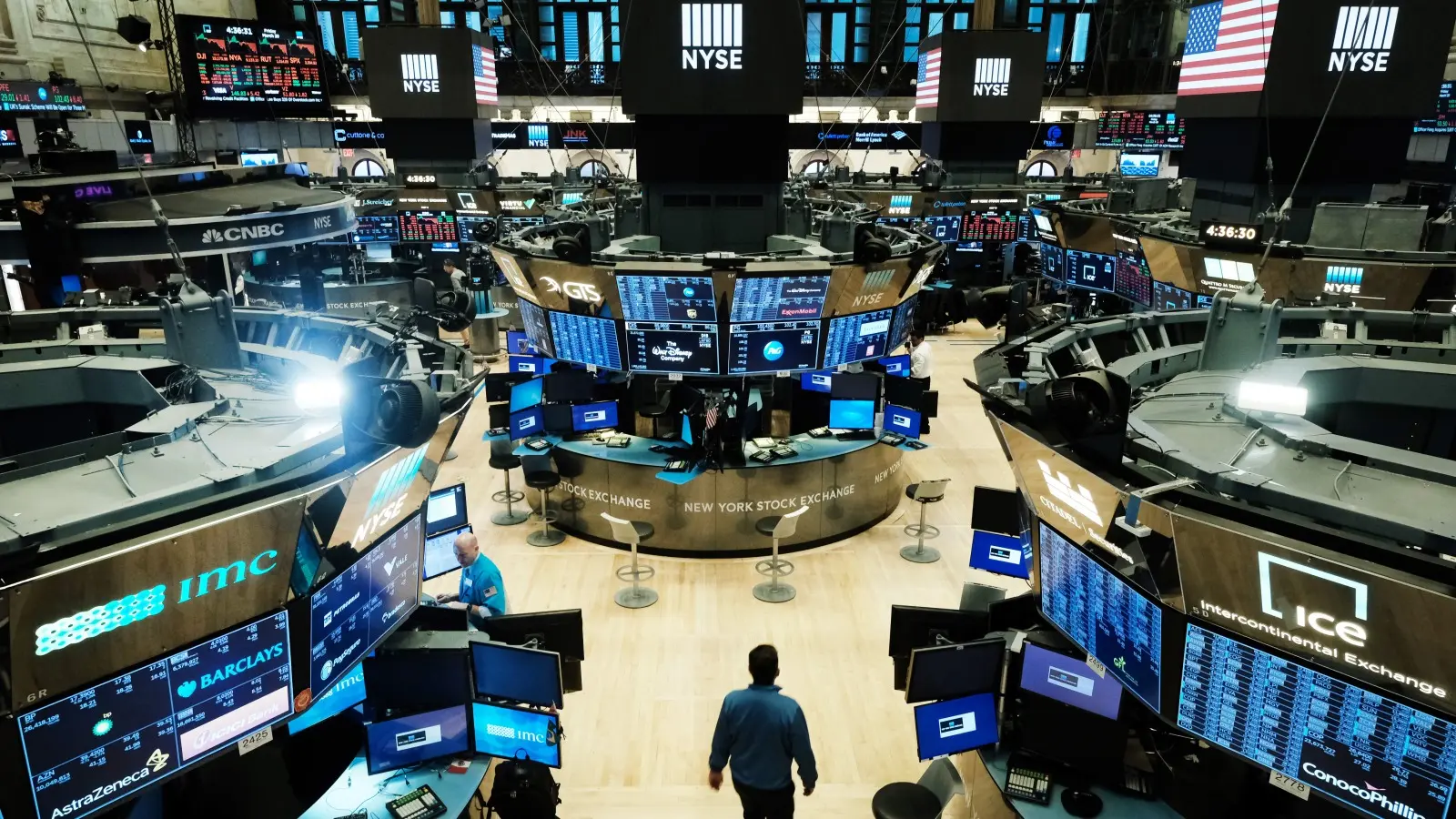 Wide shot of the New York Stock Exchange trading floor with digital displays and traders.