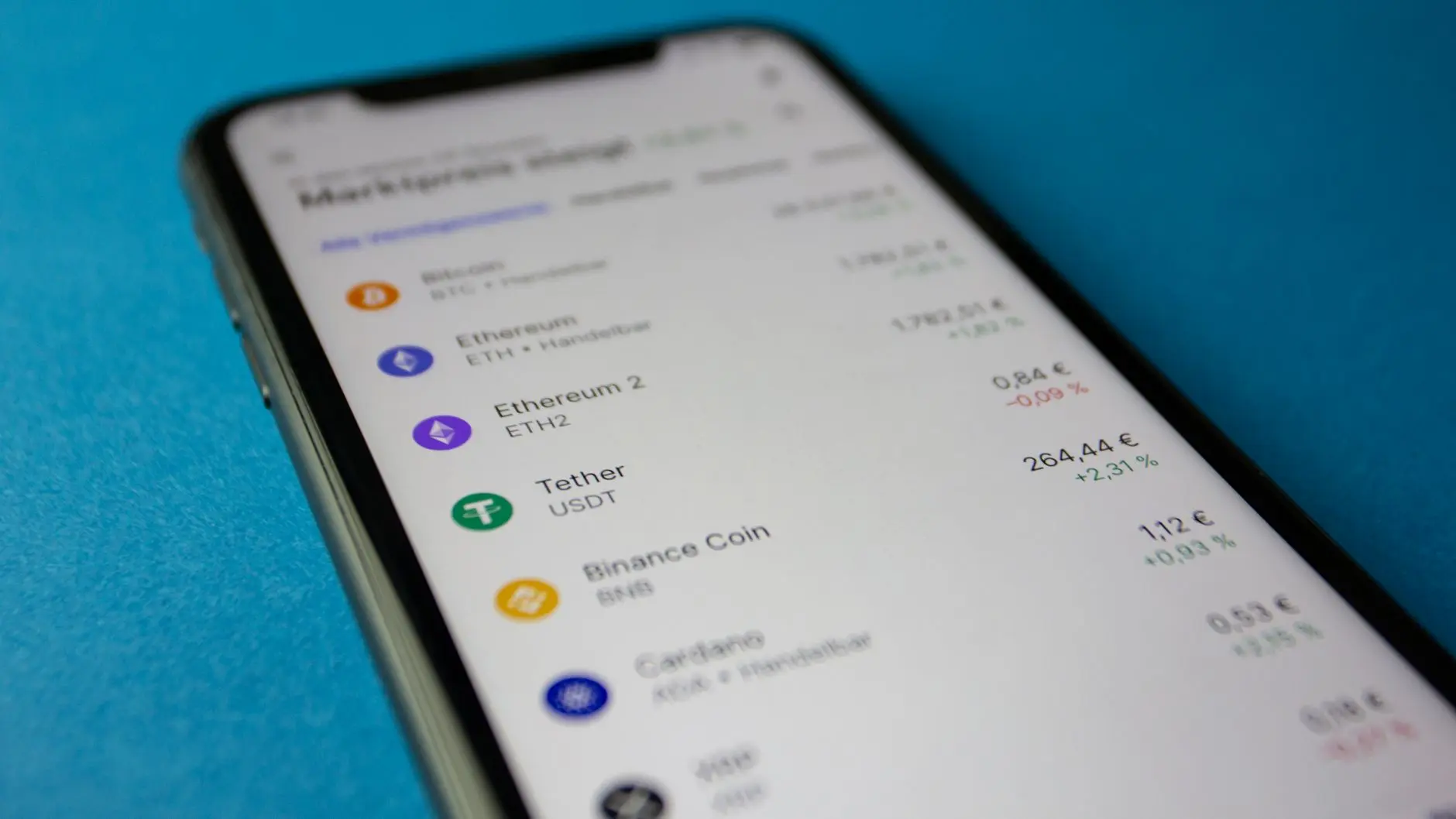 A smartphone screen displaying a list of cryptocurrencies including the Tether USDT logo and price.